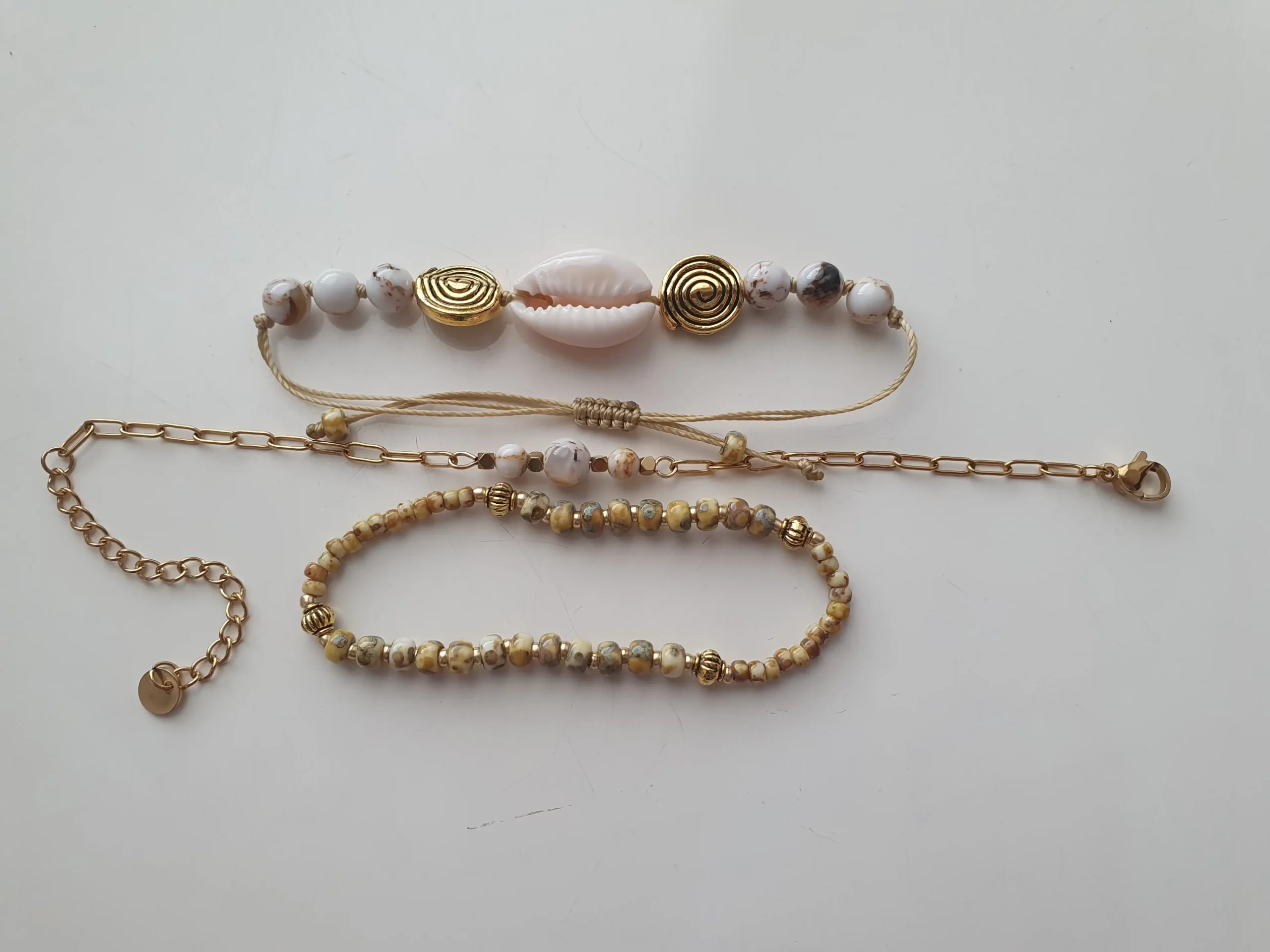 Bracelet Trio Ocealis avec coquillage cauri et perles de pierre naturelle. Modèle blanc. Vue à plat