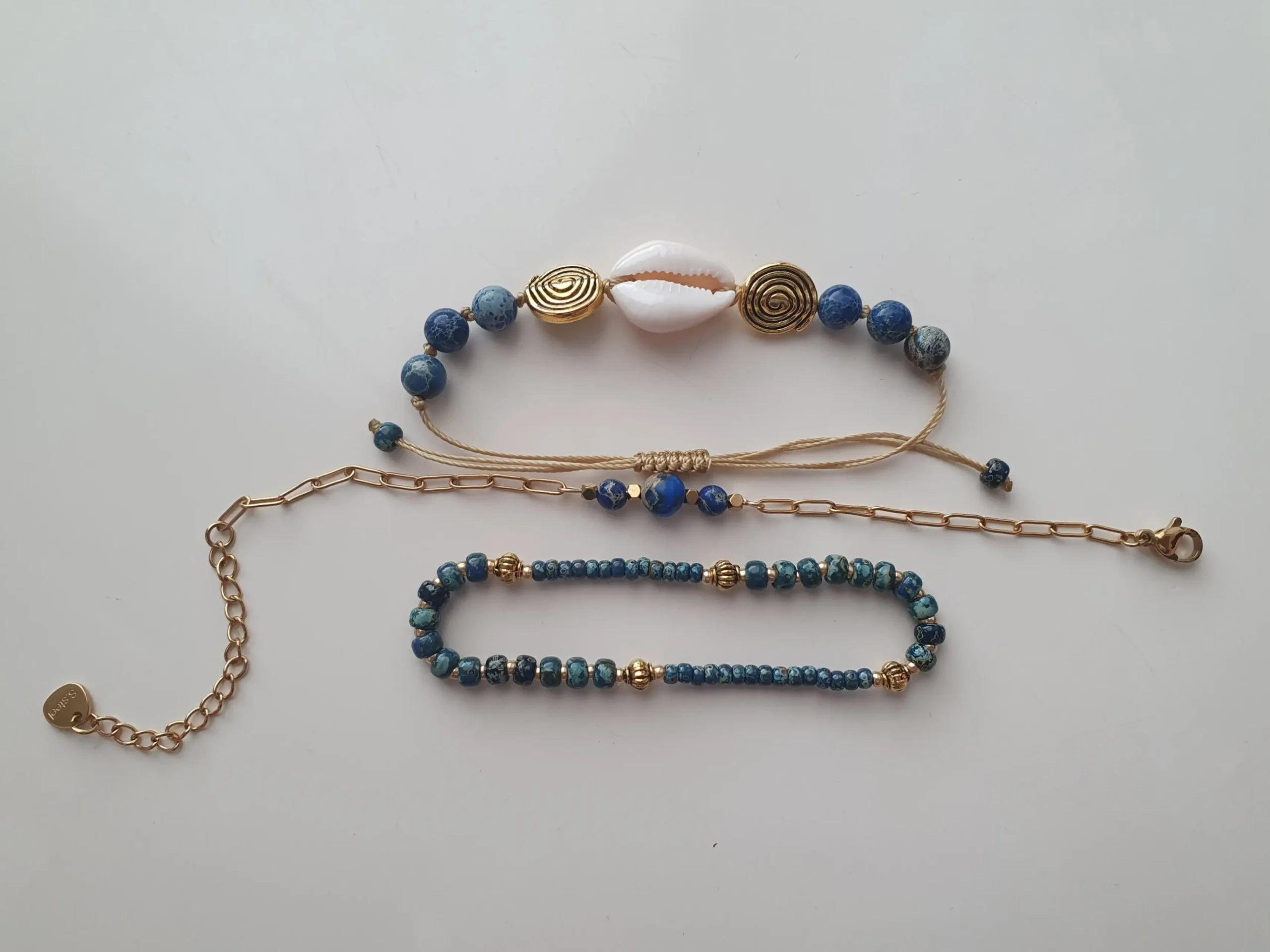 Bracelet Trio Ocealis avec coquillage cauri et perles de pierre naturelle. Modèle bleu. Vue à plat