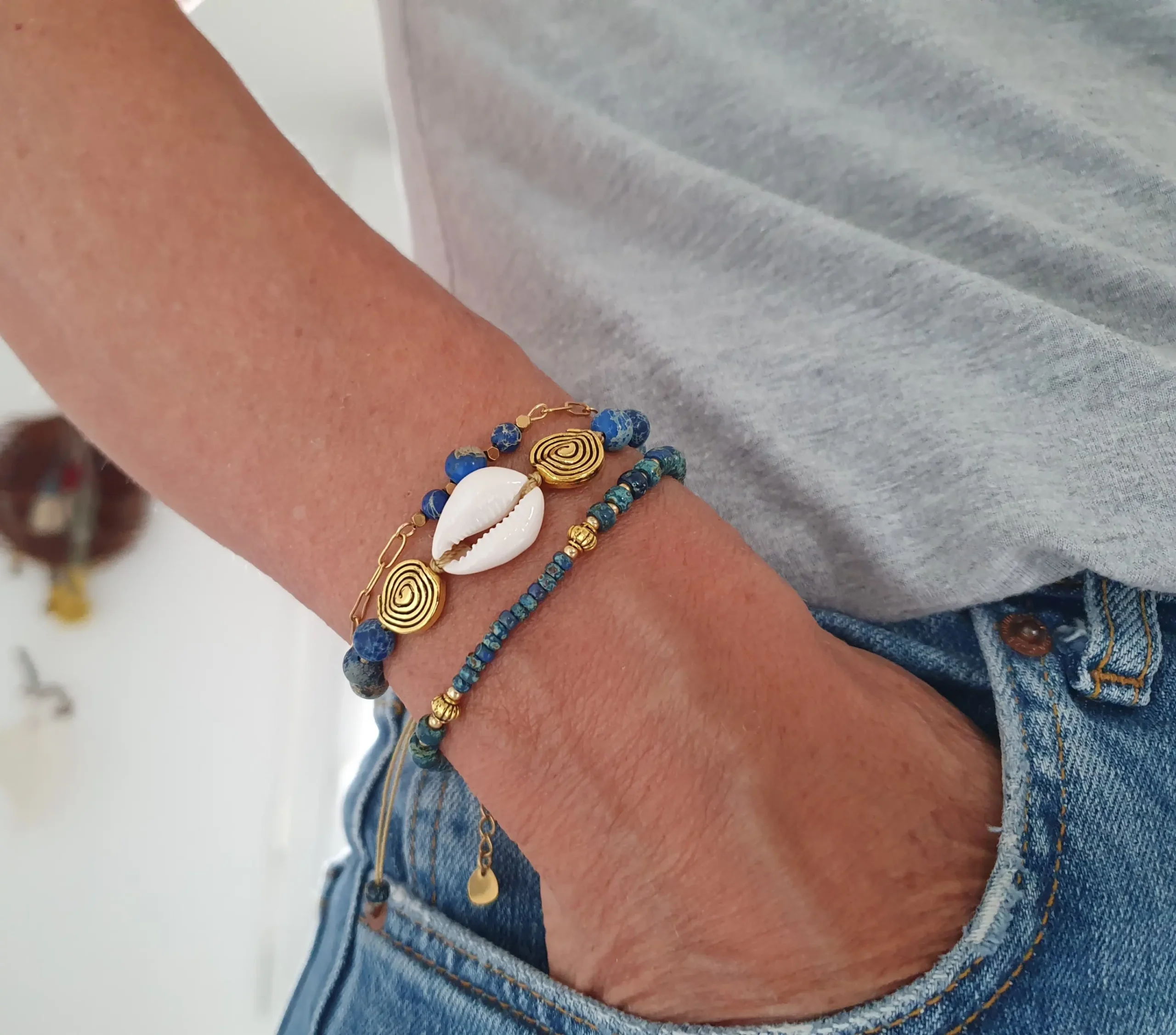Bracelet Trio Ocealis avec coquillage cauri et perles de pierre naturelle. Modèle bleu. Vue porté