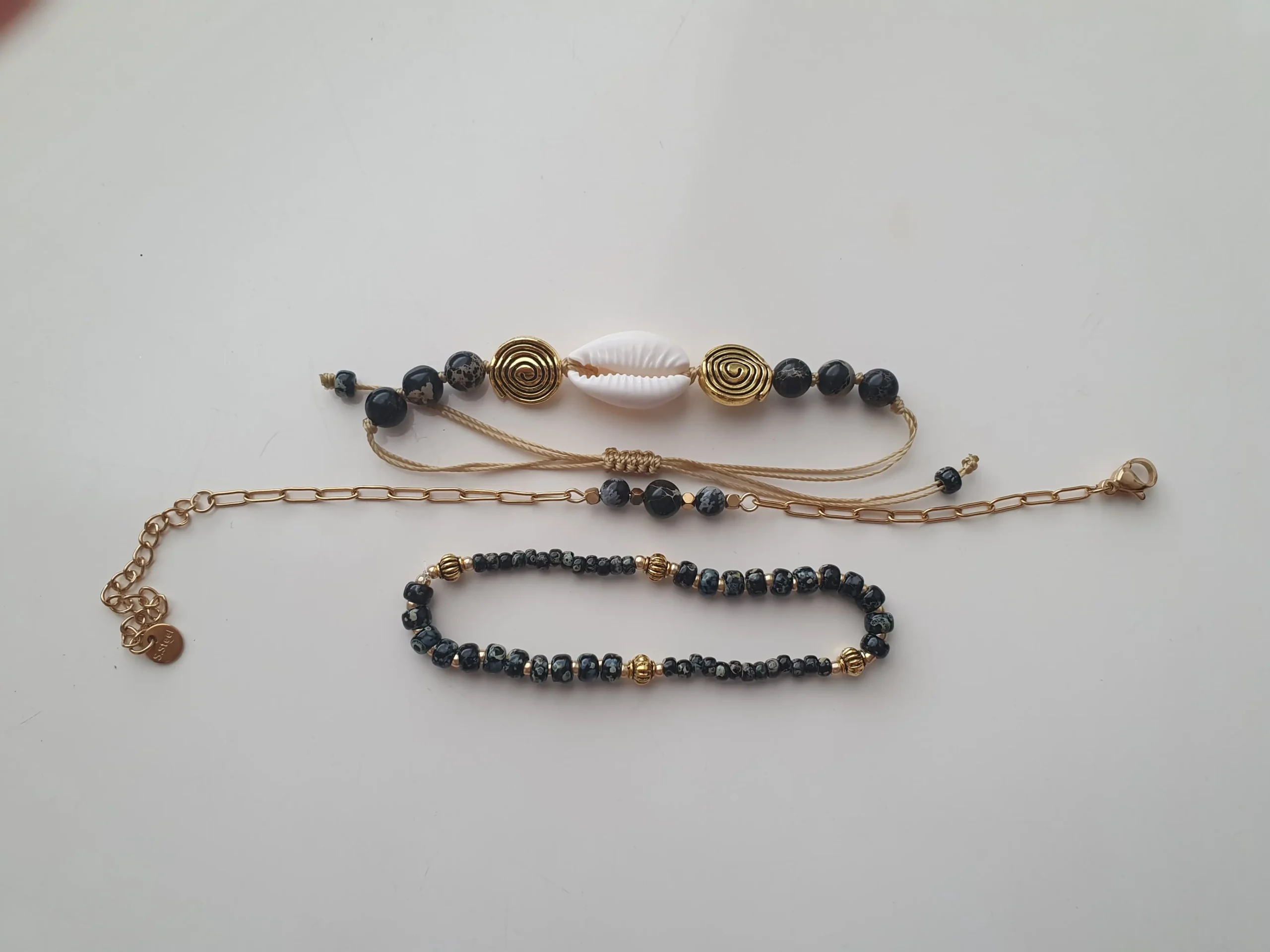 Bracelet Trio Ocealis avec coquillage cauri et perles de pierre naturelle. Modèle gris. Vue à plat