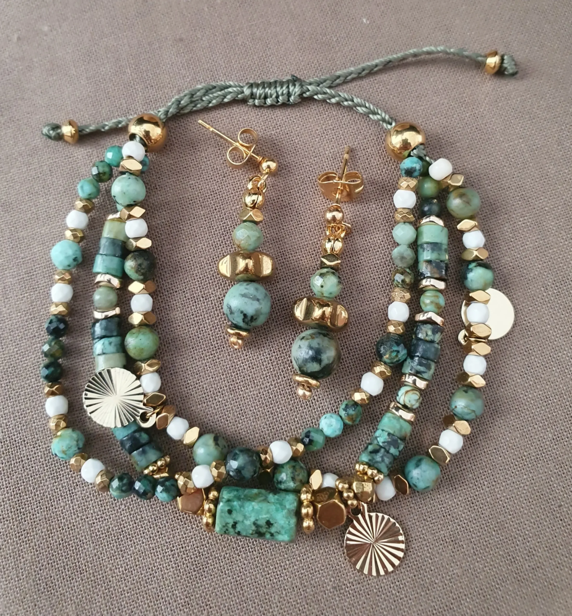 Bracelet et boucles d'oreilles Marama en perles de turquoise africaine, hématite doré et howlite avec pampilles dorées. Vue en O.