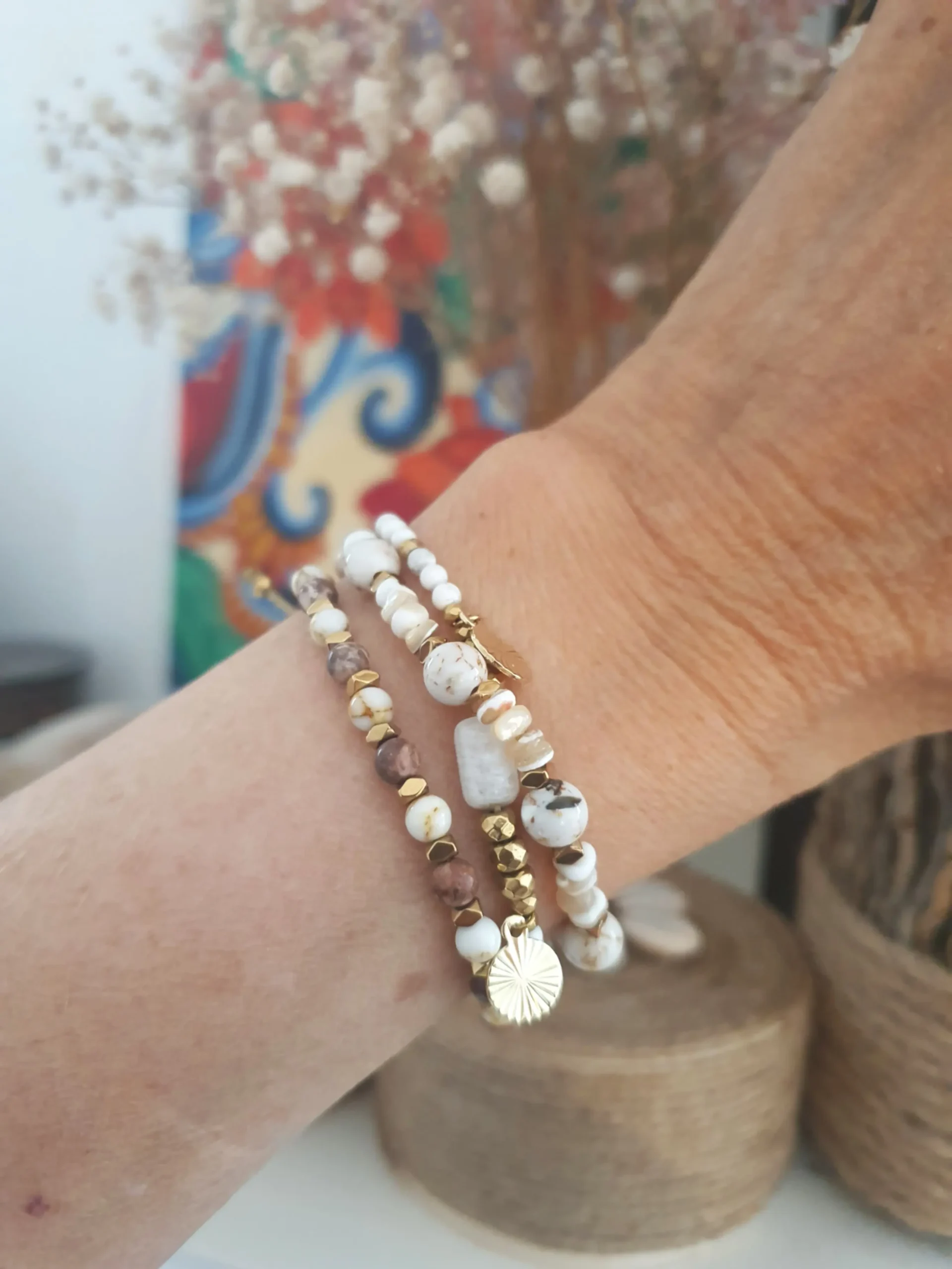 Bracelet Marama en perles de nacre,jaspe brun, pierre de lune et howlite avec pampilles dorées. Vue porté.