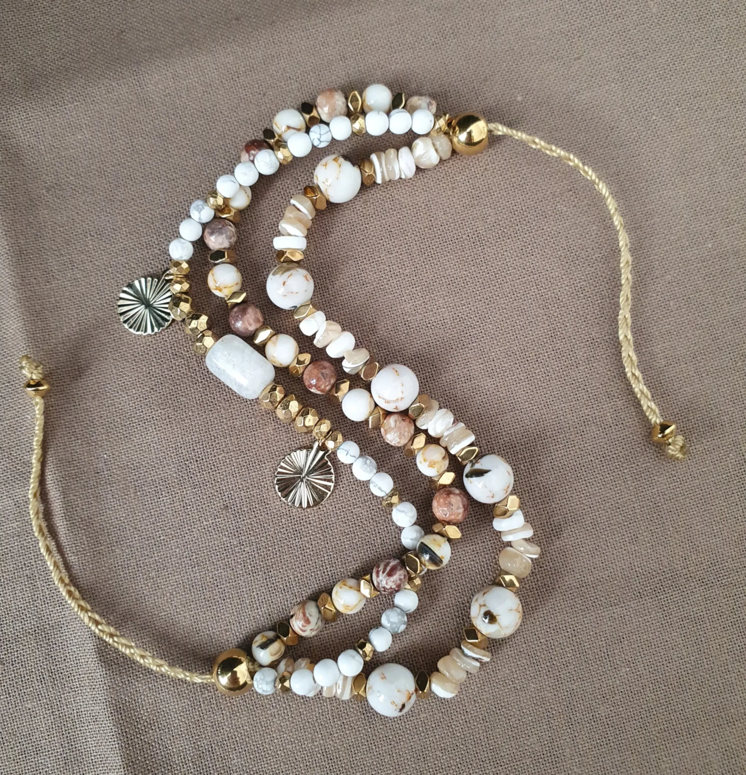 Bracelet Marama en perles de nacre,jaspe brun, pierre de lune et howlite avec pampilles dorées. Vue en S.