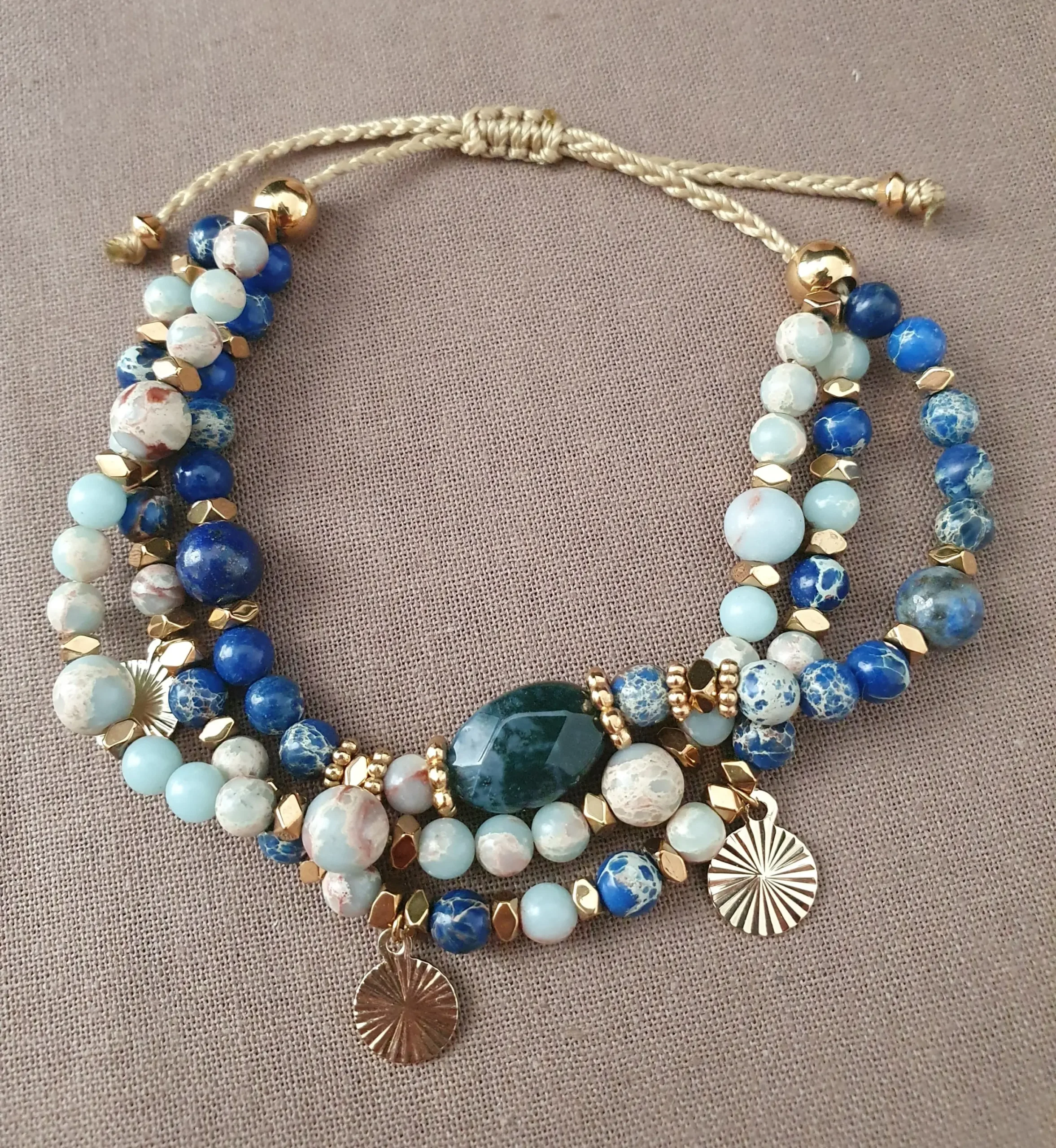 Bracelet Marama en perles de lapis lazuli, regalite, jaspe bleu et hématite doré avec pampilles dorées. Vue en O.