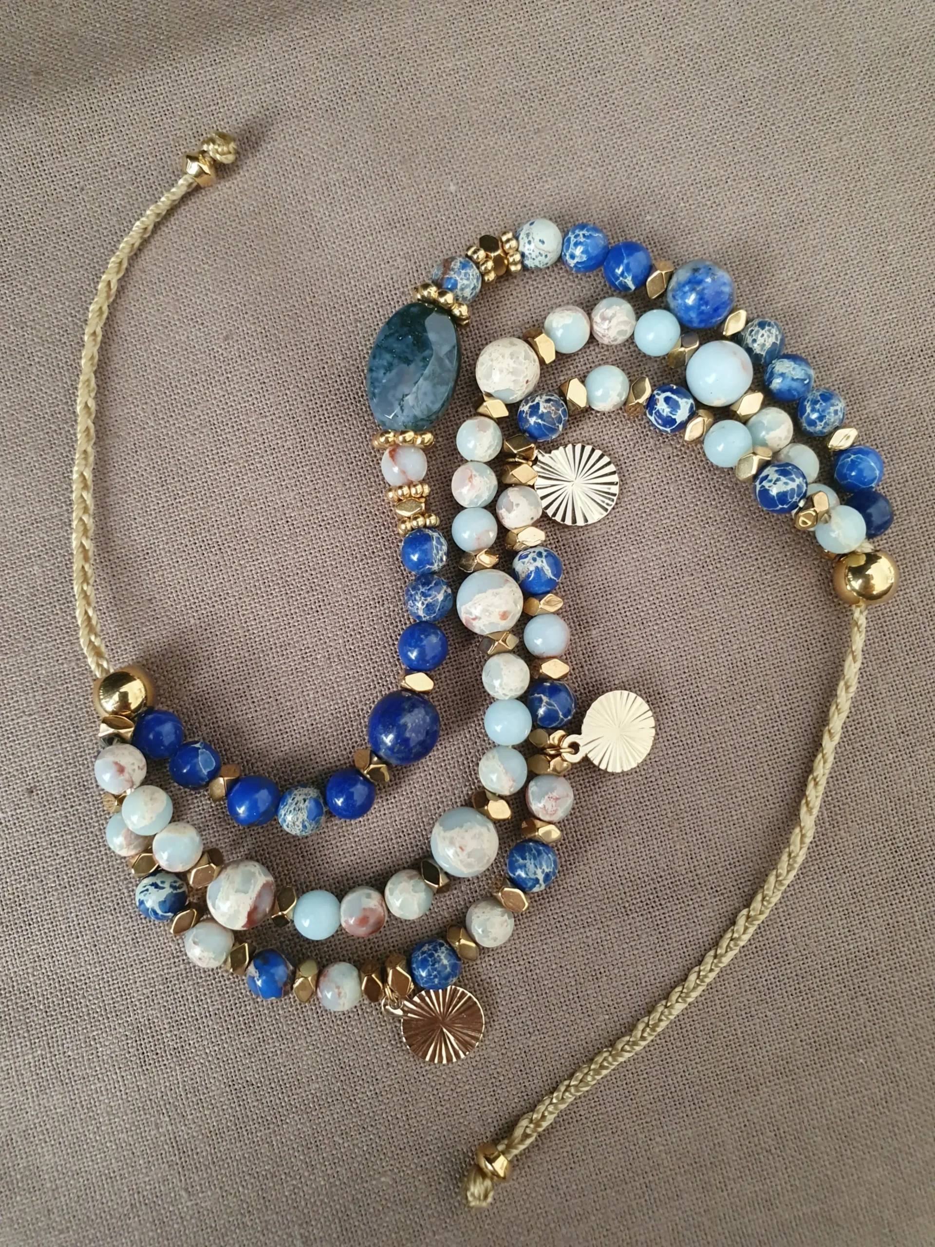 Bracelet Marama en perles de lapis lazuli, regalite, jaspe bleu et hématite doré avec pampilles dorées. Vue en S.